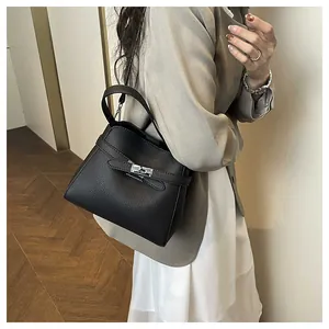 Detail of black lychee grain leather bucket bag with silver twist lock and slim strap