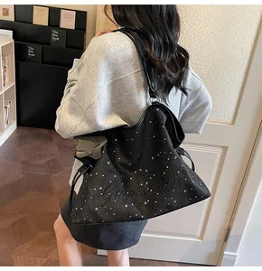 Détail du sac cabas noir avec motifs d'étoiles blanches et broderie de lettres texturées