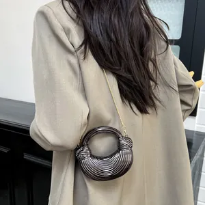 Sac croissant bronze vintage avec plis métalliques et bandoulière chaîne sur modèle