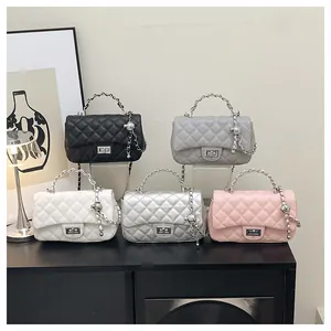 Detail view of five colors of quilted chain bags with metal ball charms and turn-locks