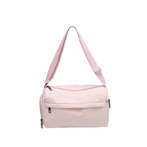 Sac bandoulière minimaliste en nylon rose clair avec sangle réglable et poches zippées