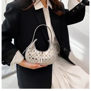 Detail of silver hobo bag with star-like metal studs and high-quality metallic finish
