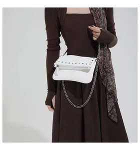 Detailed shot of white crossbody bag with silver studs and metal chain strap decoration
