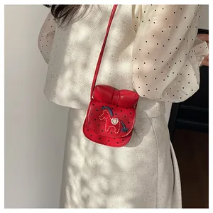 Détail du sac à bandoulière rouge à pois avec broderie cheval et grand nœud en 3D