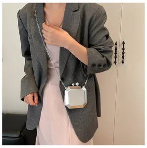 Close-up of silver geometric octagonal mini crossbody bag with metallic mirror finish