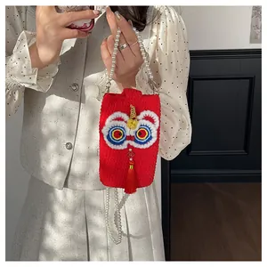 Detail of hand-woven lion dance phone bag with pearl chain and silk tassel