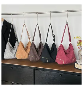 Detailed view of five large crossbody tote bags with rivets in diverse vintage colors