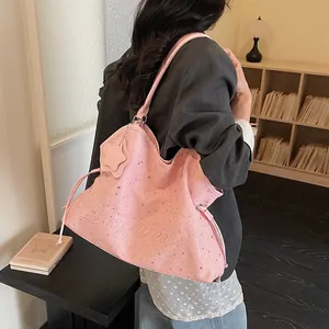 Grand sac cabas rose avec motifs étoiles et broderie porté par un mannequin dans un salon