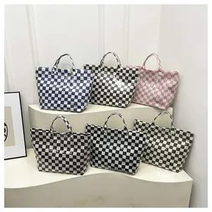 Variety of checkerboard pattern tote bags in multiple colors displayed on a white podium