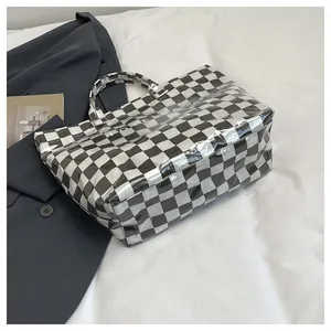 Detail of checkered tote bag with transparent PVC surface and bold TOTE BAG lettering