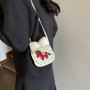Petit sac selle pour enfant blanc cassé avec pois noirs, broderie cheval et nœud chic