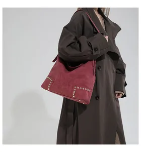 Detail shot of vintage burgundy hobo bag featuring matte finish and gold square rivets