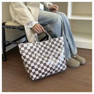 Detail of checkered tote bag with transparent PVC layer and white TOTE BAG text print