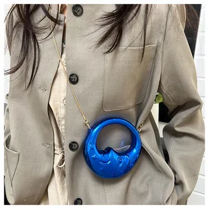 Detail of Klein blue crescent bag with star-moon embossing and golden chain strap