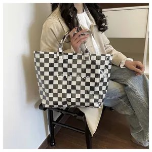 Close-up of stylish checkered tote bag with clear waterproof layer and logo