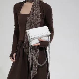Retro white leather chain handbag with silver studs and metal strap in hand