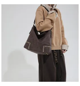 Detail of coffee brown hobo bag with matte finish and stylish gold square rivets