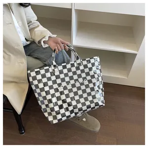 Detail of checkered tote bag showing glossy texture and white TOTE BAG typography