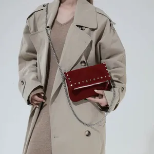 Vintage burgundy suede crossbody bag with silver rivets and metal chain strap on model