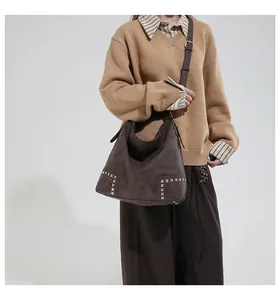 Detailed close-up of vintage brown suede tote bag with gold stud accents and large capacity