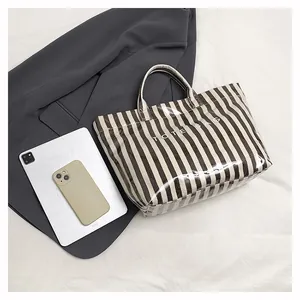 Vue à plat du sac cabas à rayures marron avec tablette et mobile pour le bureau