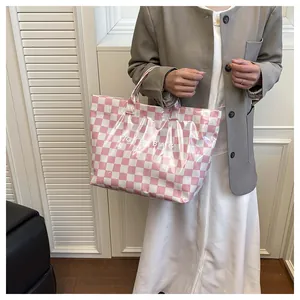 Detail of pink checkerboard tote bag with clear PVC layer and white Note Bag text