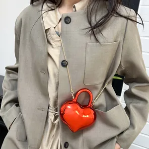 Mini red heart-shaped handbag with glossy metallic finish and gold chain strap