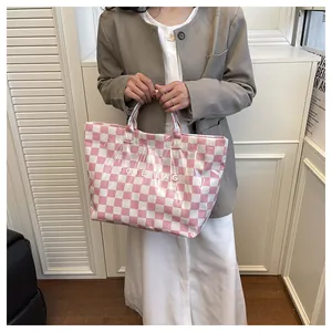Detail view of pink checkered tote bag with clear waterproof PVC outer layer and white text