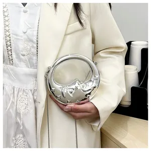 Detail of silver mirror crescent bag with metallic texture and elegant chain strap