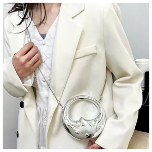 Detail of silver crescent bag featuring a metallic moon relief and hollow circular frame