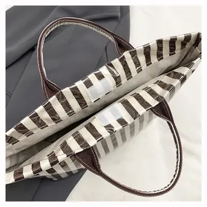 Détail du sac cabas rayé montrant le revêtement PVC étanche et la fermeture velcro