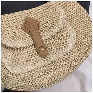 Detailed close-up of handmade straw woven texture with a brown faux leather buckle strap