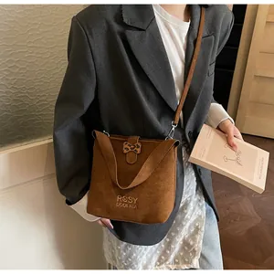 Brown suede crossbody bag with leopard print bow detail and embroidery shown on model