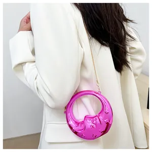 Detail of rose purple crescent bag with metallic mirror finish and golden chain