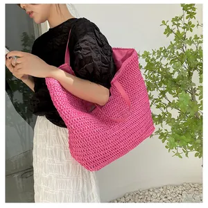 Detail of fuchsia woven straw tote bag showing large capacity and vibrant texture