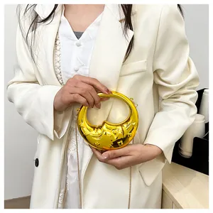 Detail shot of a golden crescent moon handbag with mirror finish and star engravings