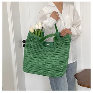 Detail of green woven tote bag featuring soft crochet texture and leather handle