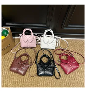 Detail of five mini shirt-style crossbody bags in assorted colors on a textured rug