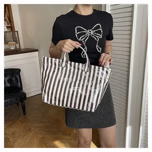 Détail d'un sac cabas à rayures avec couche imperméable transparente et texte logo