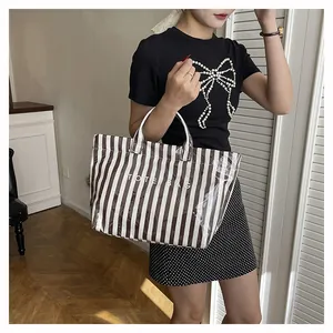 Vue détaillée du sac cabas rayé marron et blanc avec texte imprimé étanche