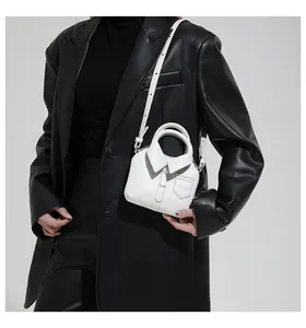 Detail view of mini shirt-style crossbody bag with collar and button design on black blazer