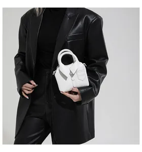 Close-up of white leather handbag with creative shirt collar and button details