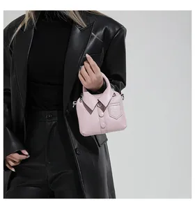 Detail of light pink shirt-shaped mini handbag featuring fine stitching and decorative pocket