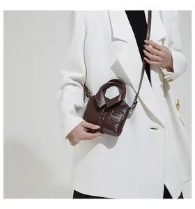 Detail view of dark brown shirt-shaped crossbody bag with buttons and collar design