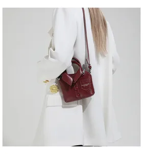 Detail view of burgundy handbag with creative suit collar design and polished leather finish