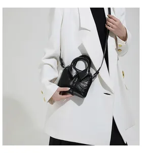 Detail of creative shirt-style black mini bag with polished finish and button decor