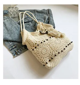 Close-up of bohemian crochet tote bag featuring intricate openwork patterns and fringe detail