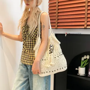 Bohemian off-white crochet tote bag with floral cutouts and tassel for beach vacations