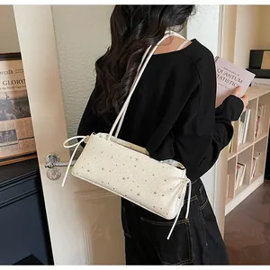 Détail du sac à bandoulière blanc à étoiles avec nœud à cordon sur le côté