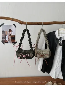 Detail of ruched shoulder bag handles and vintage bow accents on wooden beam display